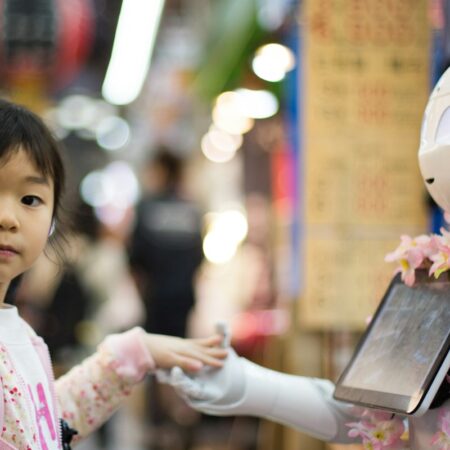 photo of girl laying left hand on white digital robot