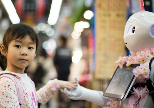 photo of girl laying left hand on white digital robot