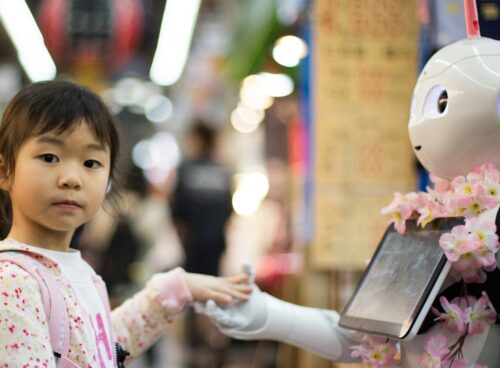 photo of girl laying left hand on white digital robot