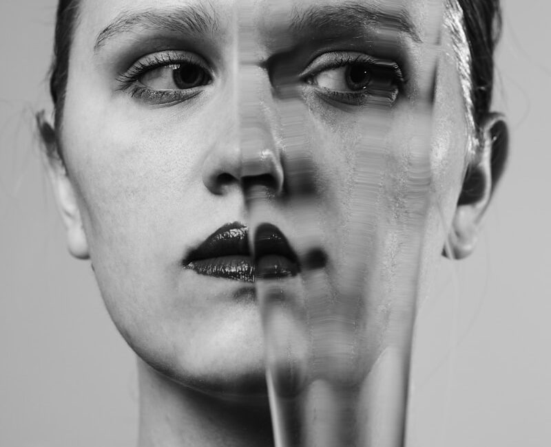 a woman's face is shown through a broken glass