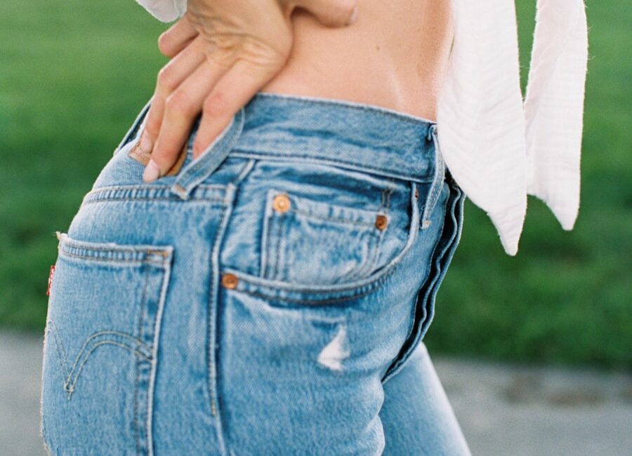 woman in blue tattered denim jeans and white crop top shirt
