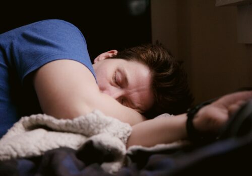 woman in blue shirt lying on bed