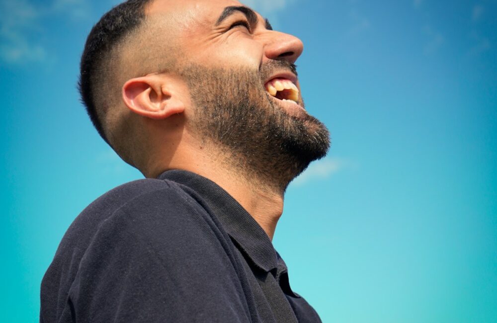 smiling man wearing black collared top