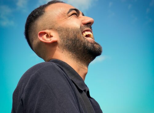 smiling man wearing black collared top