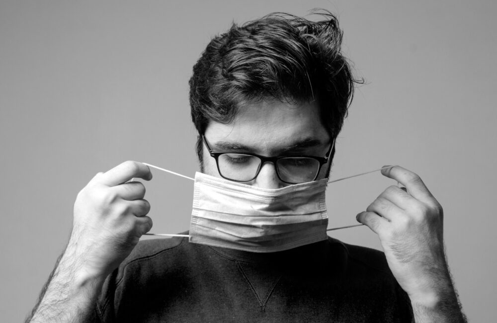 man in black crew neck shirt holding white paper