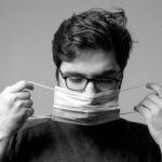 man in black crew neck shirt holding white paper