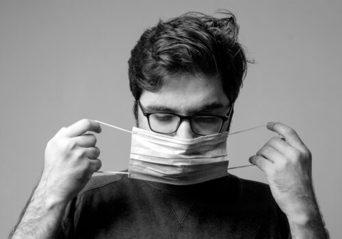 man in black crew neck shirt holding white paper