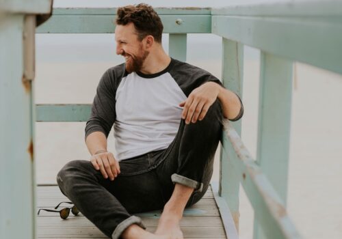 man smiling while sitting on floor during daytime
