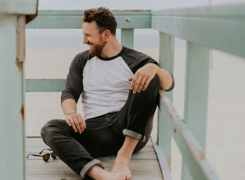 man smiling while sitting on floor during daytime