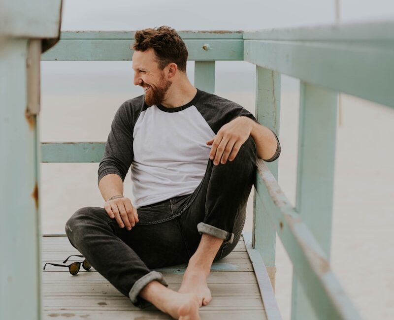 man smiling while sitting on floor during daytime