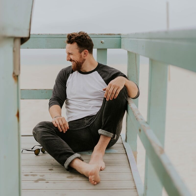 man smiling while sitting on floor during daytime