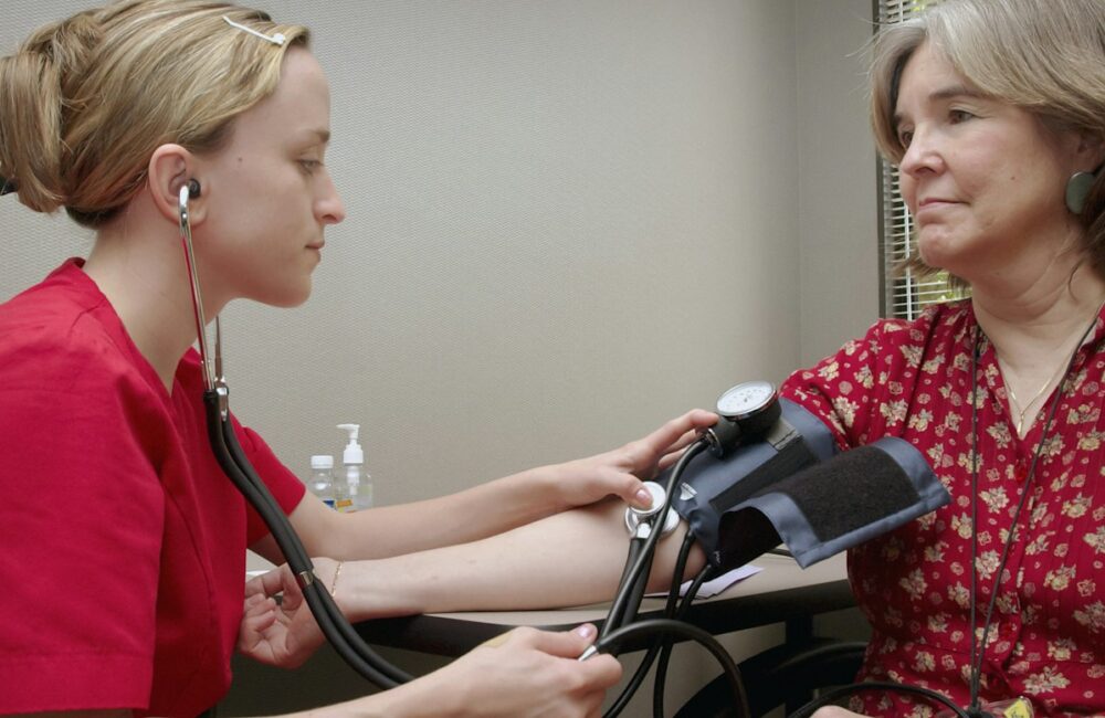 a woman with a stethoscope listening to a patient