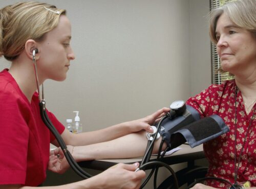 a woman with a stethoscope listening to a patient