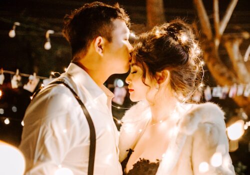 man kissing woman's forehead