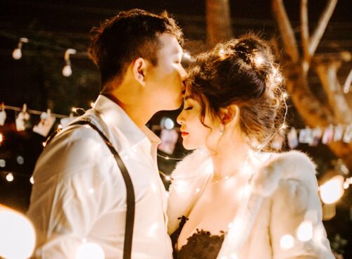 man kissing woman's forehead