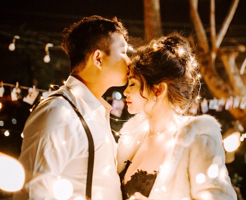 man kissing woman's forehead