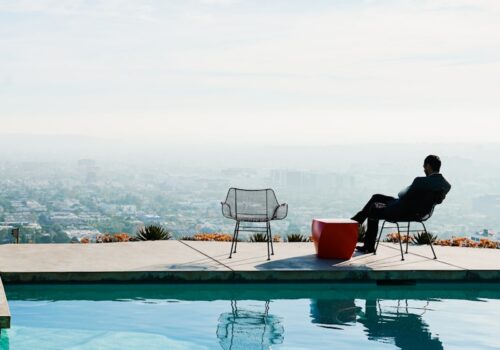 a person sitting in a chair by a pool