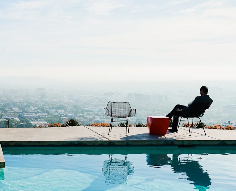 a person sitting in a chair by a pool