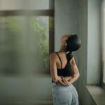 A woman leaning against a wall with her head in her hands