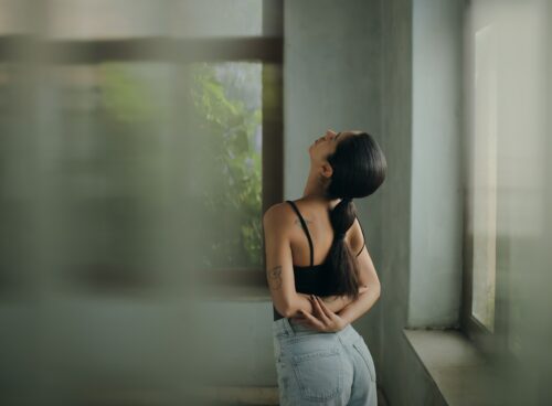A woman leaning against a wall with her head in her hands