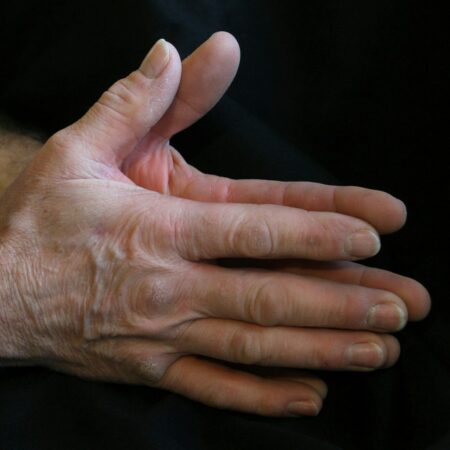a person's hands with a black background
