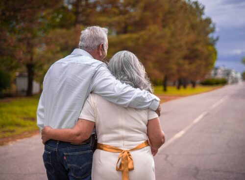 couple kissing on the road during daytime