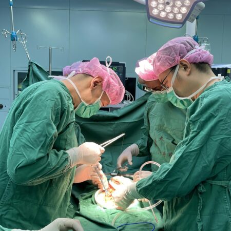 Surgeons performing a medical operation in a hospital operating room.