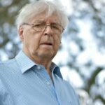 selective focus photography of man wearing blue and white striped collared top